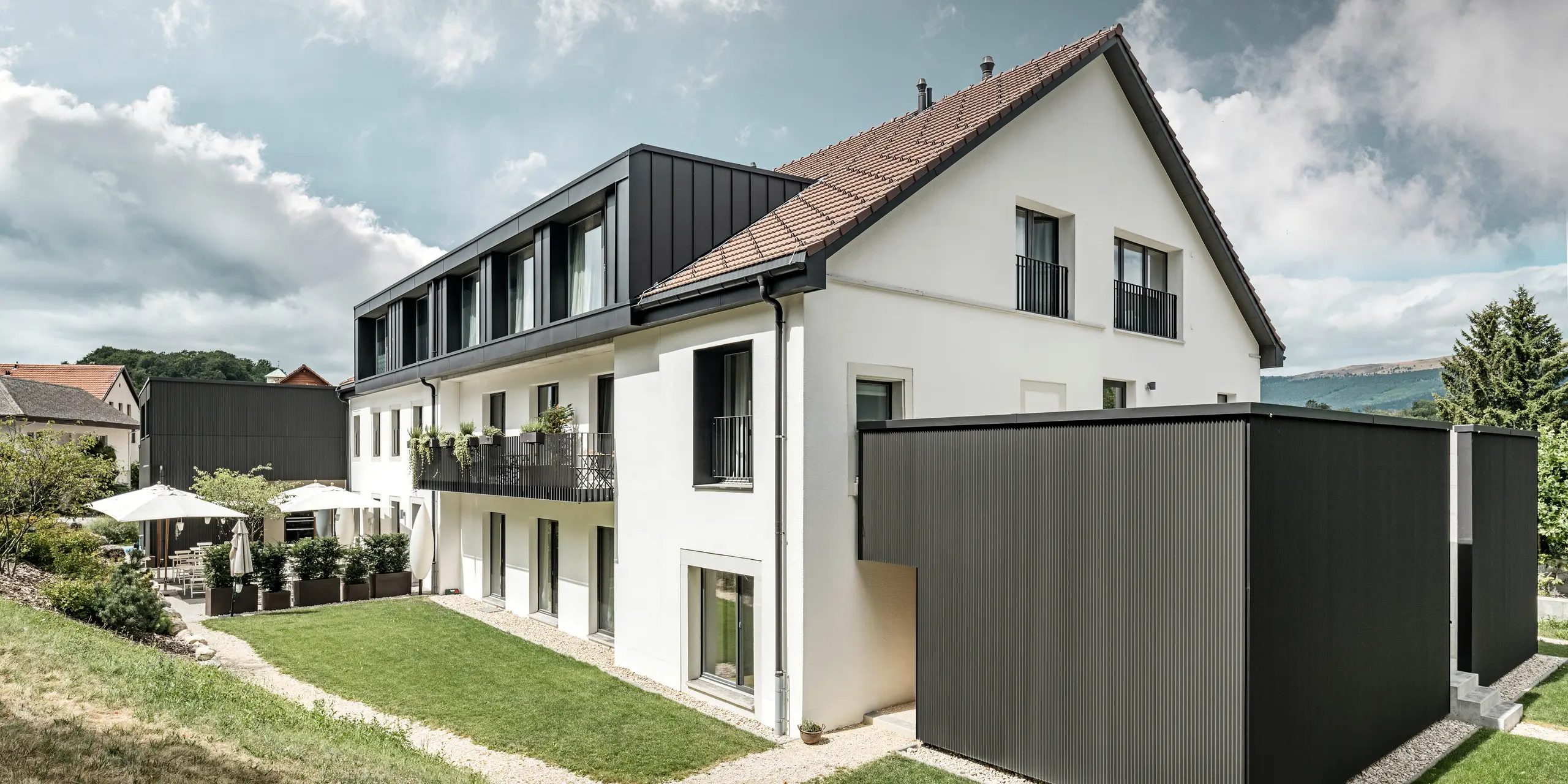 PREFA Zackenprofil in der Sonderfarbe Schwarzgrau auf dem Hôtel de l’Ours in Prêles, Schweiz