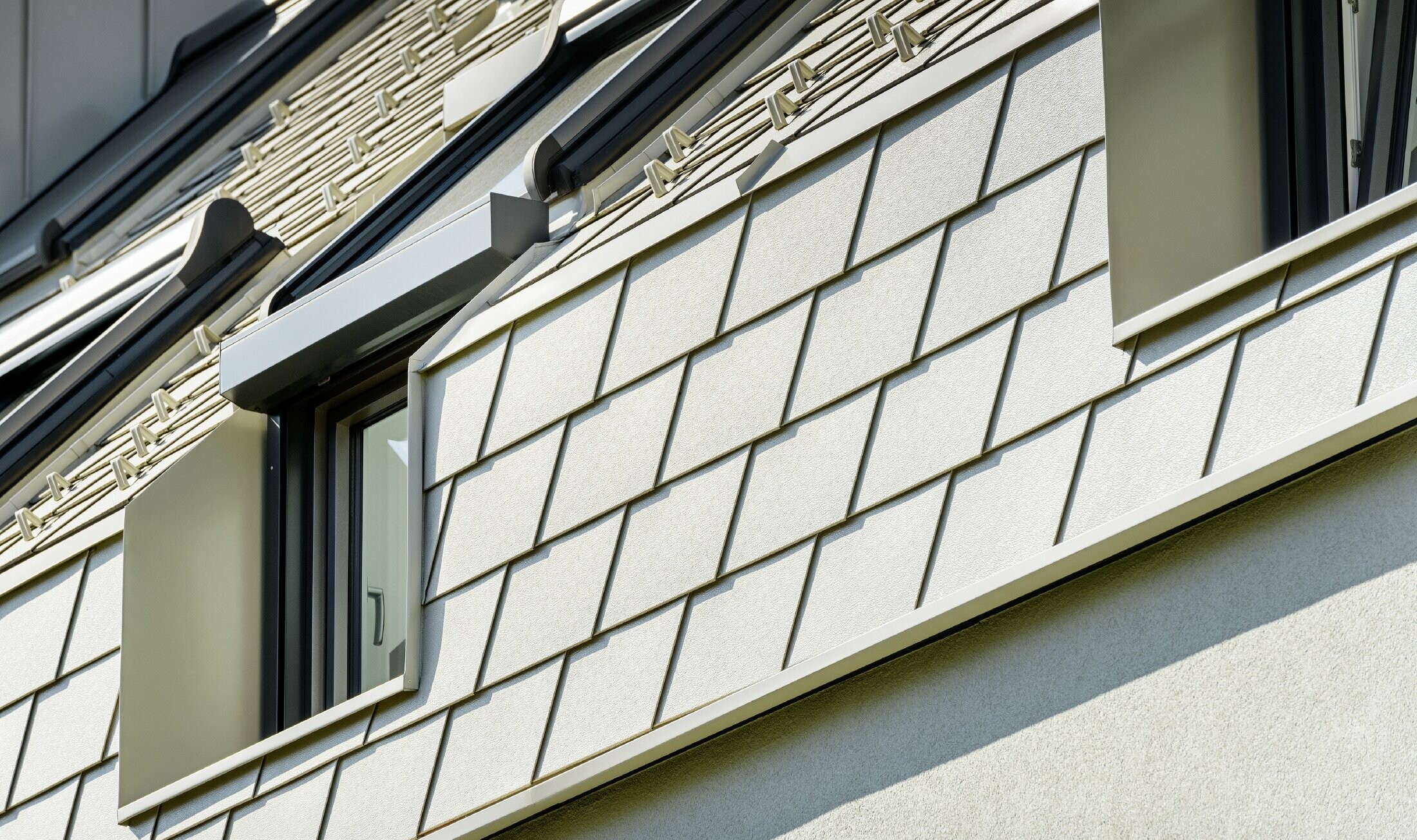 New residential complex with a large aluminium roof surface and a host of roof windows