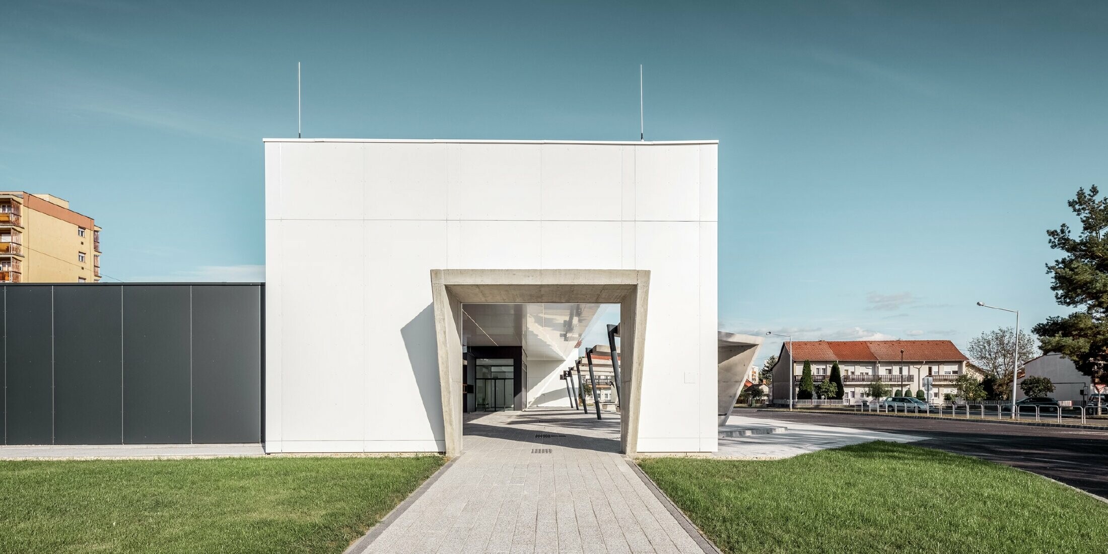 Lateral view of the railway station in Lenti, Hungary. A passageway to the bus stops is visible.