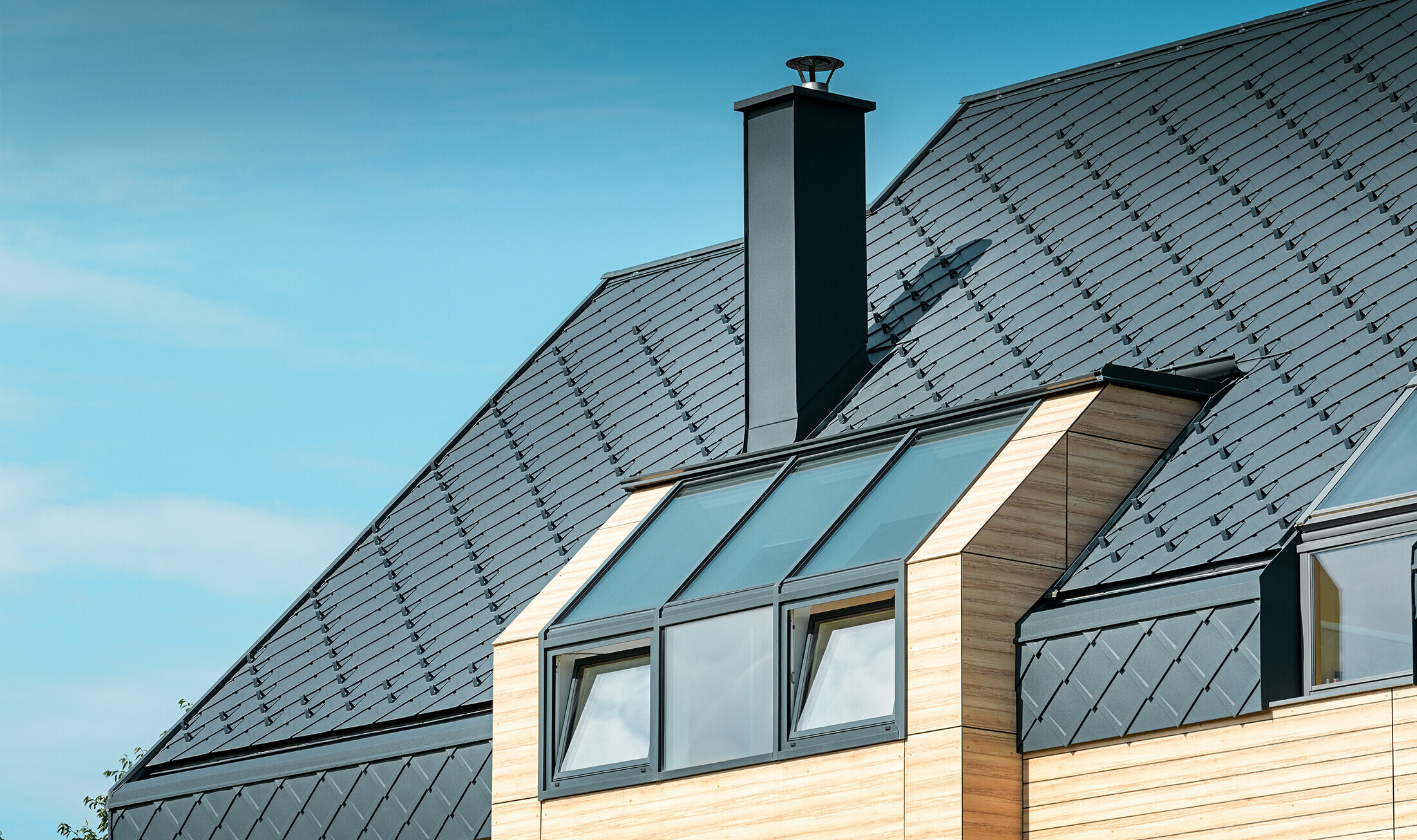 Detached house with gable roof without eaves with a wooden-look façade and an anthracite aluminium roof