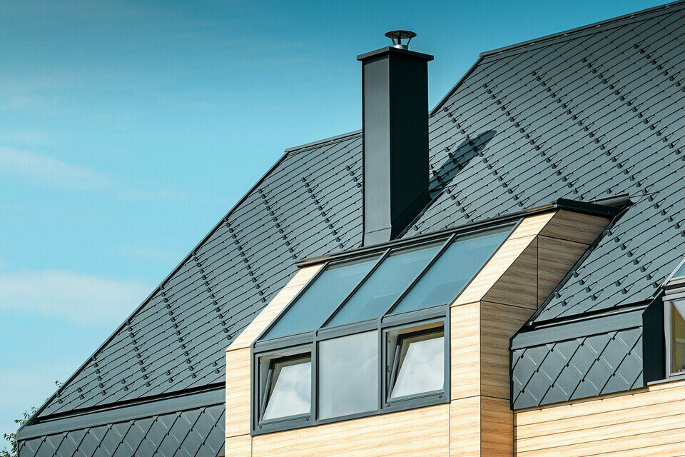 Detached house with gable roof without eaves with a wooden-look façade and an anthracite aluminium roof