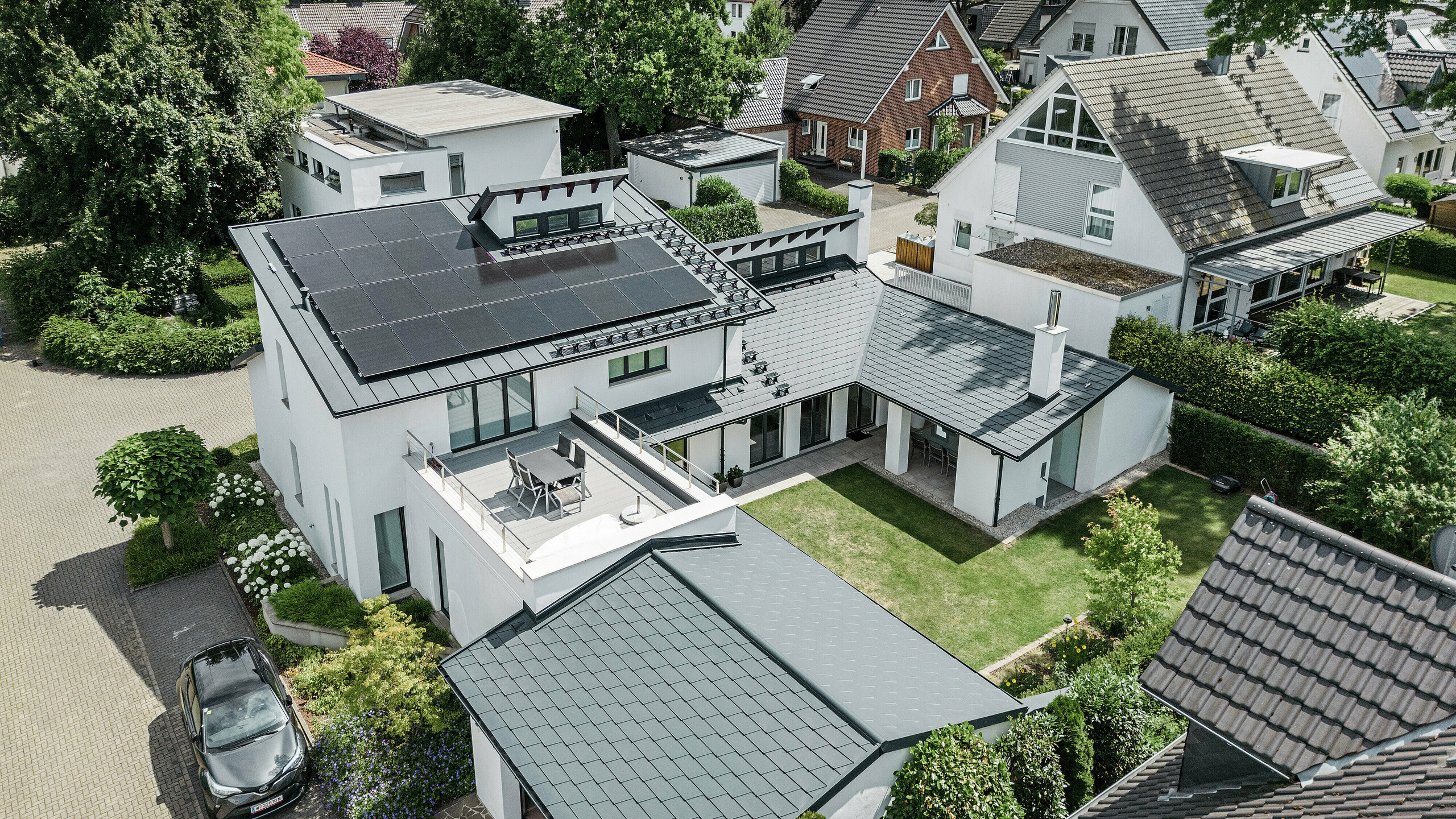 Bird's eye view of the outstanding roof landscape of a detached house in Dortmund with PREFA roof shingles DS.19 and PREFALZ in P.10 anthracite as well as a large-scale PV system