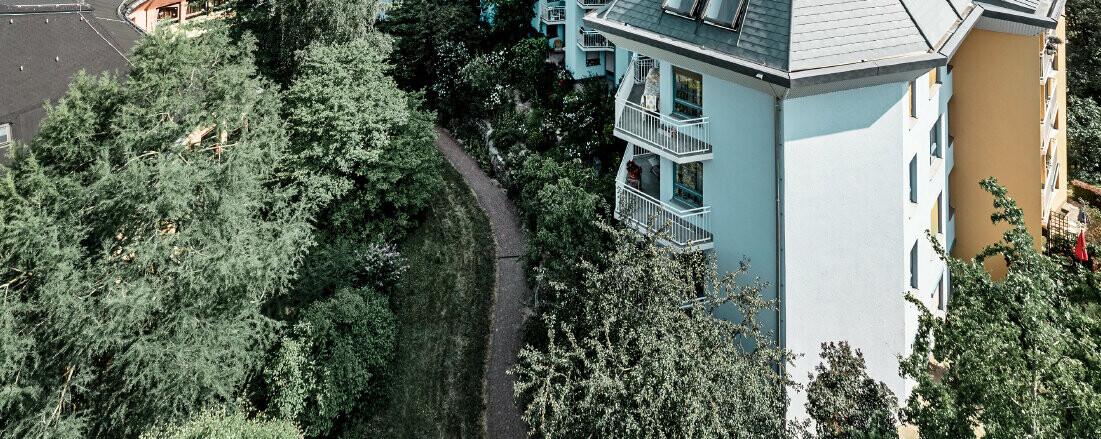 Large aged-care facility covered with the PREFA roof shingles and Prefalz in stone grey with numerous balconies.