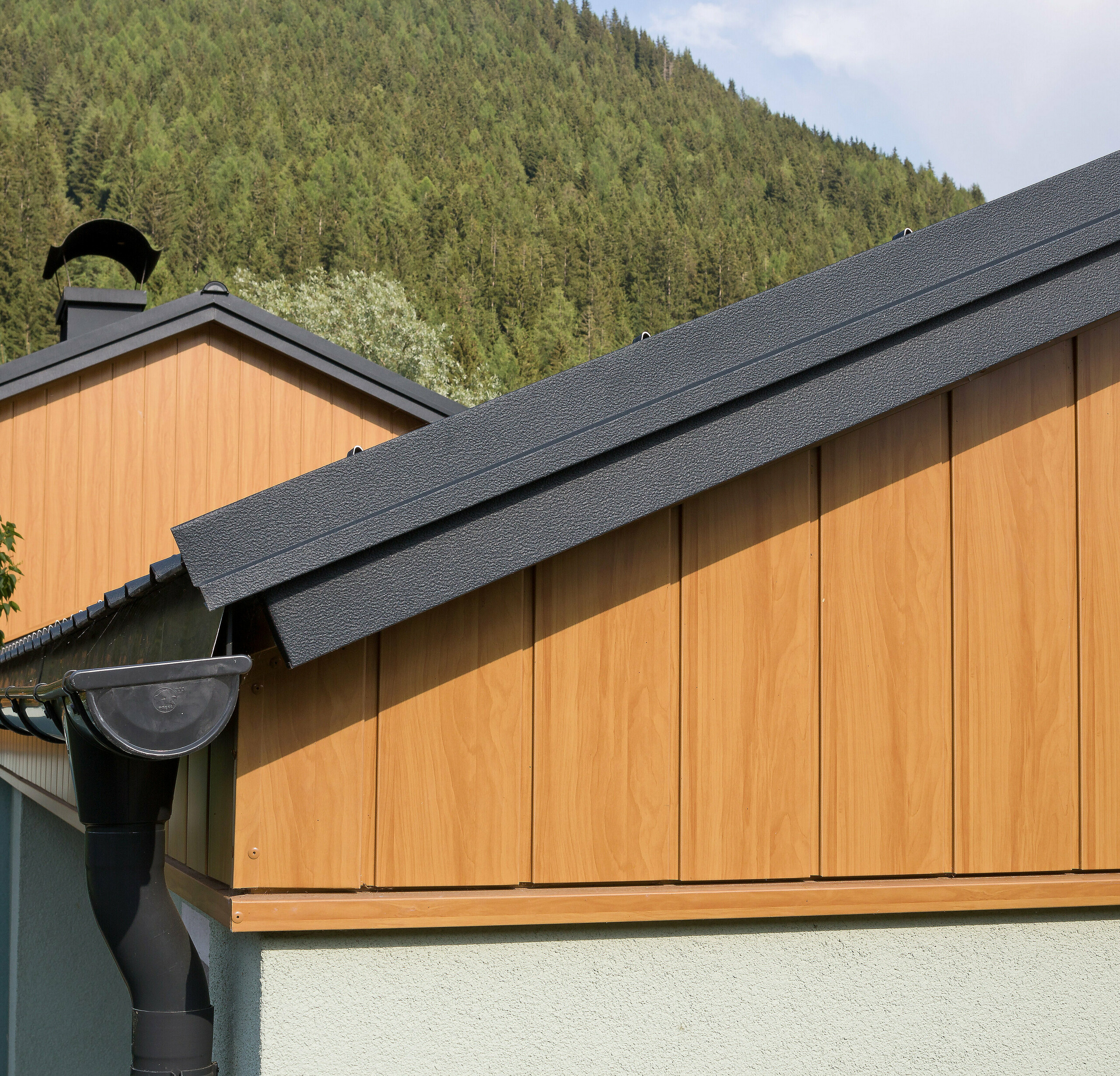 PREFA gable cladding vertical sidings natural oak roof gutter Gable cladding with aluminium sidings from PREFA in natural oak, installed vertically with a PREFA roof gutter in anthracite.