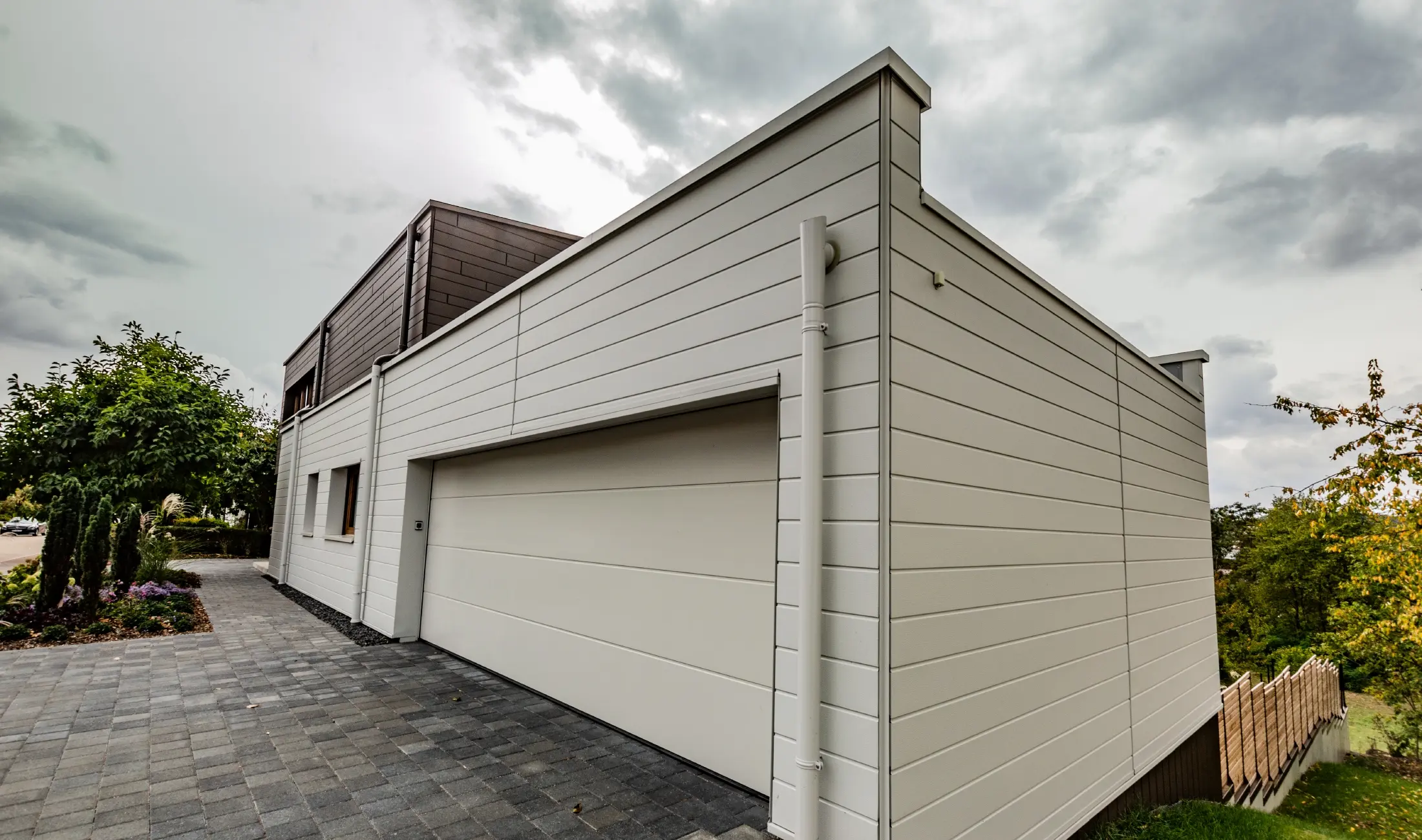 Garage cladding with horizontally installed PREFA siding in white together with the PREFA parapet outlet connector.
