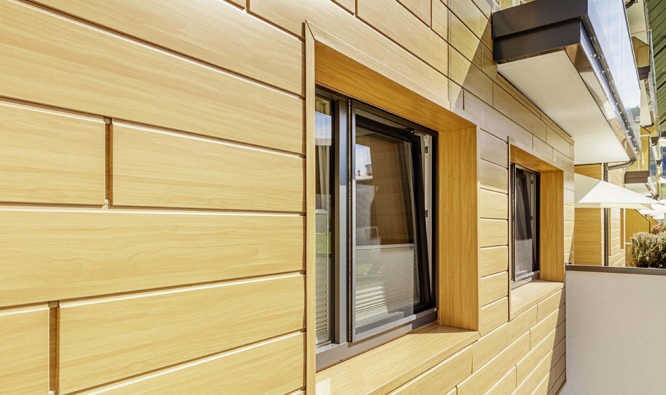Detailed close up of a window surround with PREFA sidings in a wood finish at the Guthof Lutz in Schattwald.