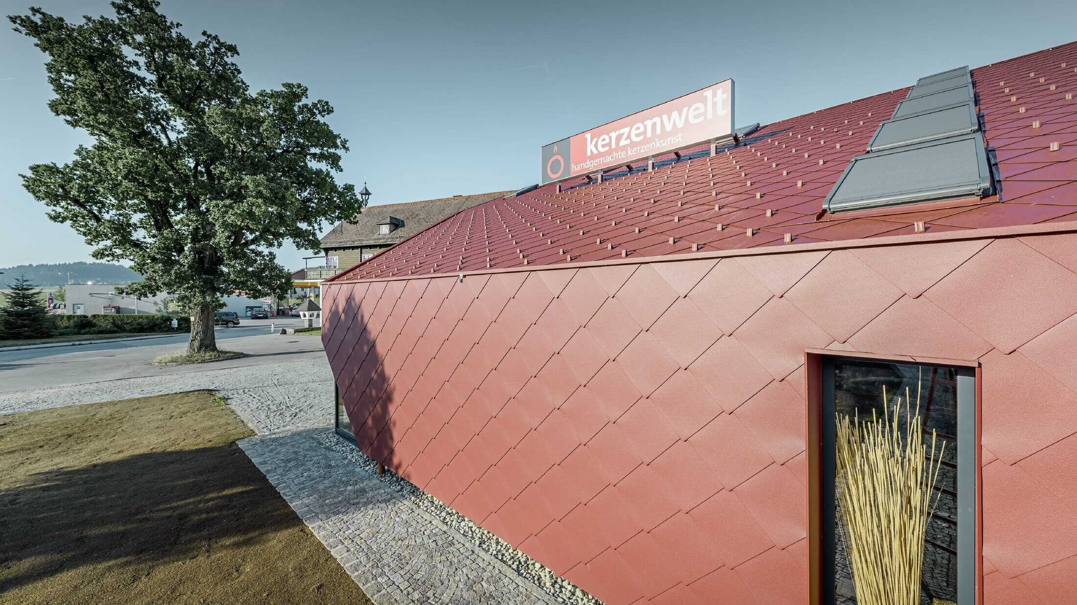 The Kerzenwelt candle store in Schlägl was completely reclad in the PREFA rhomboid tile. The 44 x 44 rhomboid façade tile in oxide red was used for the roof cover and the façade cladding.