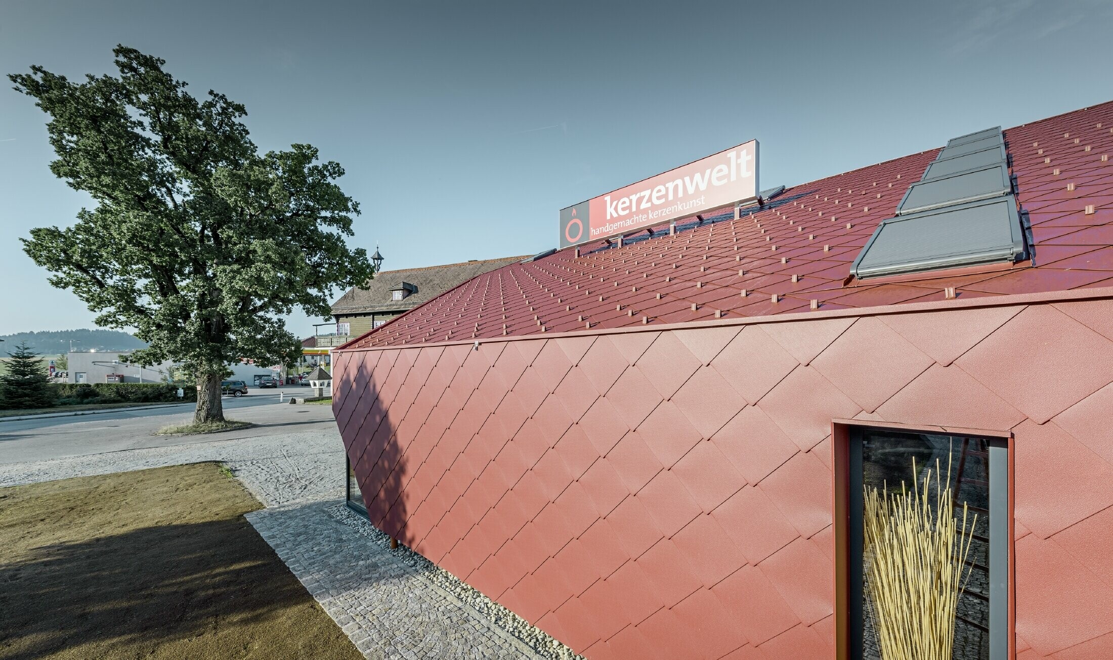 The Kerzenwelt candle store in Schlägl was completely reclad in the PREFA rhomboid tile. The 44 x 44 rhomboid façade tile in oxide red was used for the roof cover and the façade cladding.