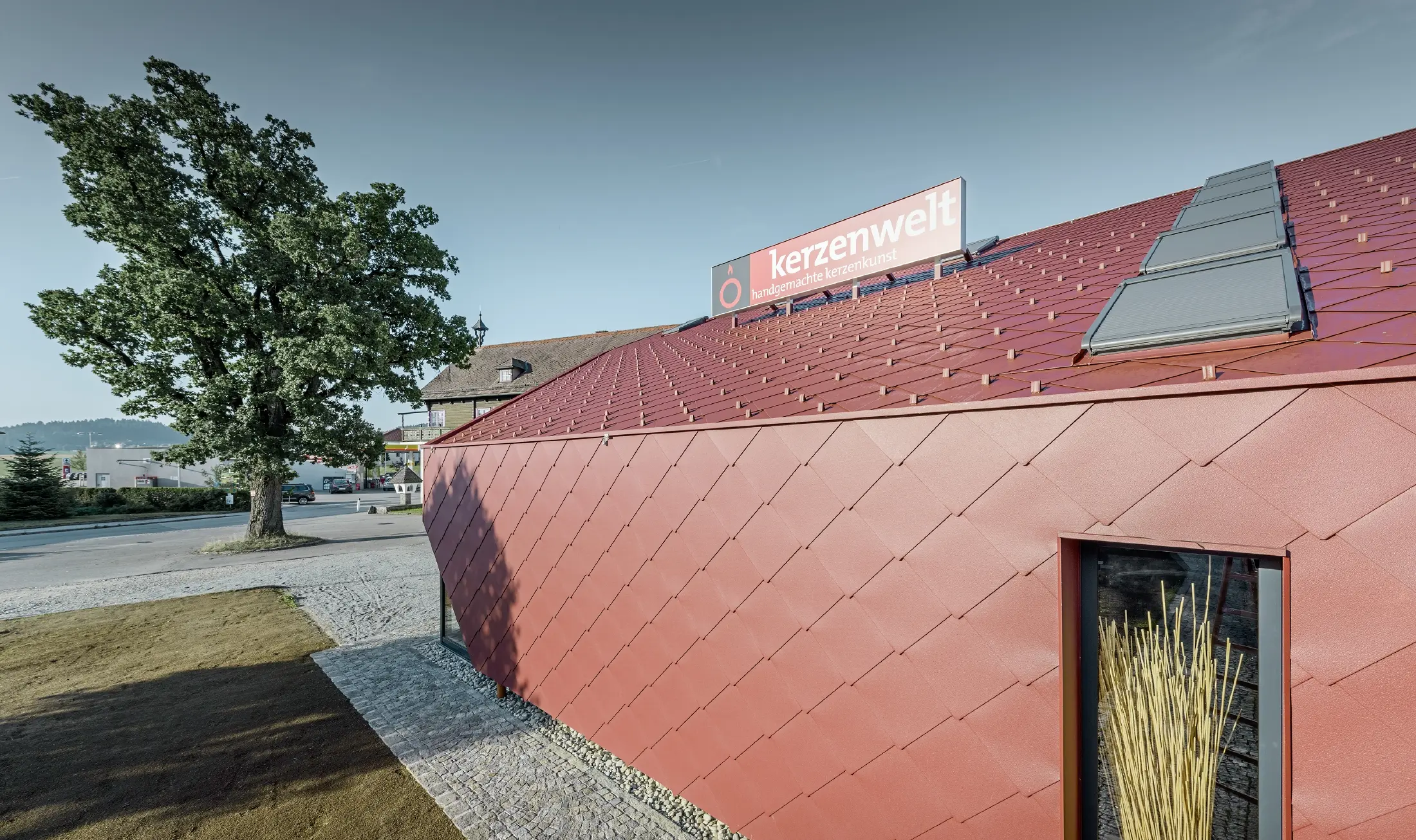 The Kerzenwelt candle store in Schlägl was completely reclad in the PREFA rhomboid tile. The 44 × 44 rhomboid façade tile in oxide red was used for the roof cover and the façade cladding.
