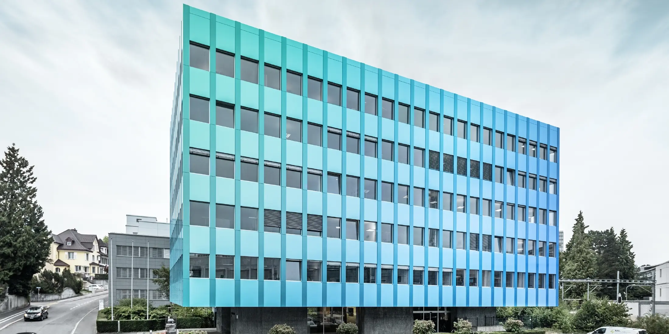 Side view of the Wielandhaus in Aarau; the façade is clad with PREFABOND aluminium composite panel made of aluminium from PREFA, which shimmer in blue-green thanks to a special coating process.