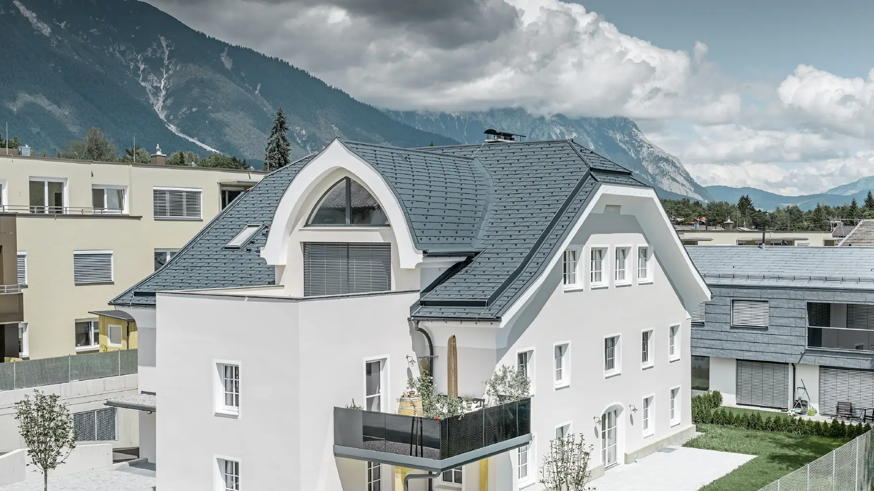 Newly renovated half-hipped roof with PREFA roof shingles in P.10 anthracite with curved dormer