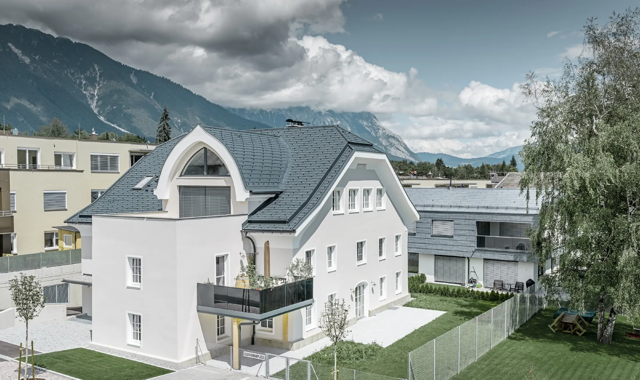 Newly renovated half-hipped roof with PREFA roof shingles in P.10 anthracite with curved dormer