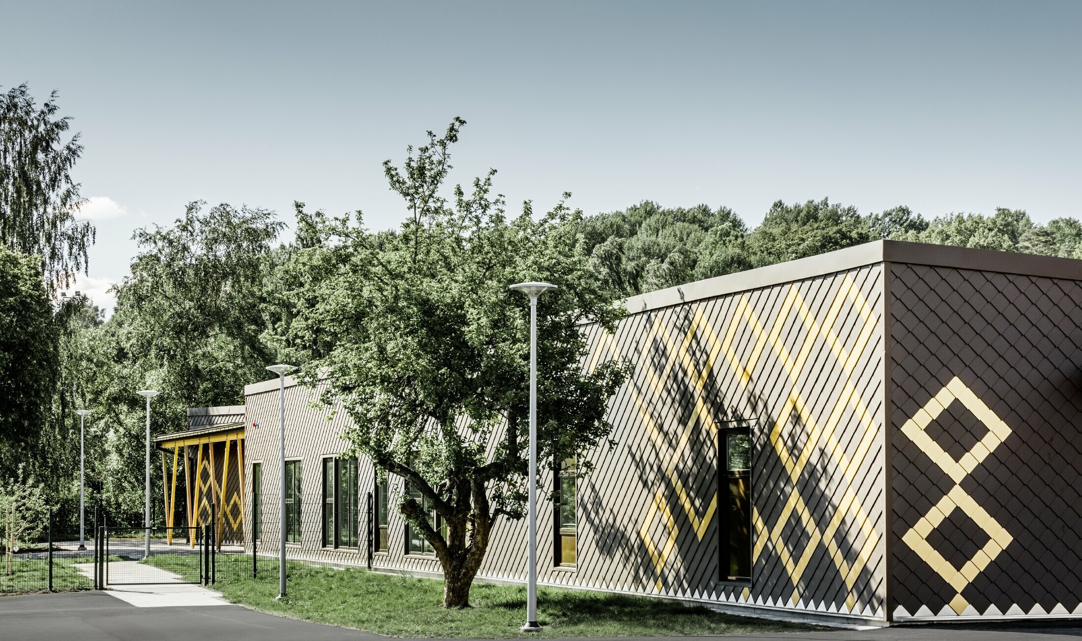 The nursery school in Stockholm was clad in the durable PREFA aluminium façade. The rhomboid tiles in brown and Mayan gold create an interesting pattern.