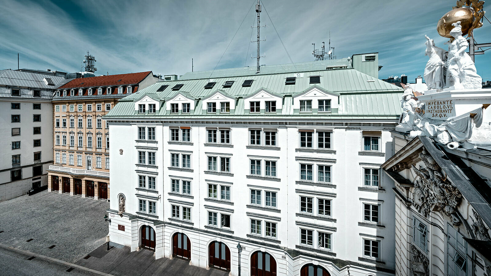 View of the central fire station am Hof in Vienna, surrounded by several buildings. The roof is clad with Prefalz in P.10 patina green.