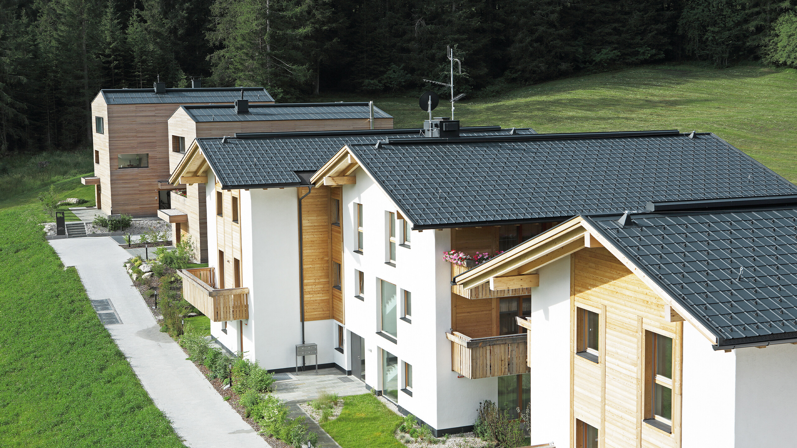 The five residential buildings in Corvara were covered with PREFA roof tiles and standing seams in anthracite, made of storm-proof aluminium.