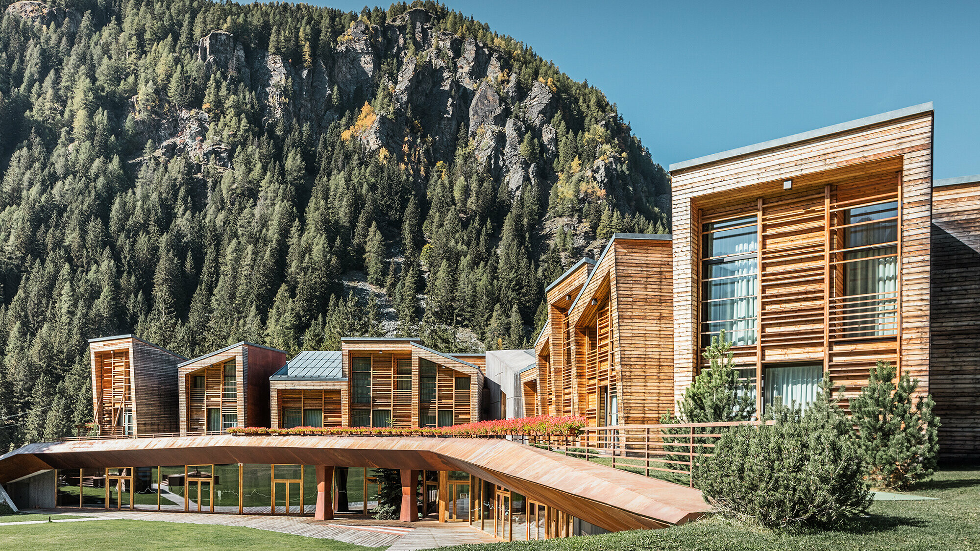 Side view of the upper and lower areas of the CampZero resort in the Aosta Valley with mountains in the background.
