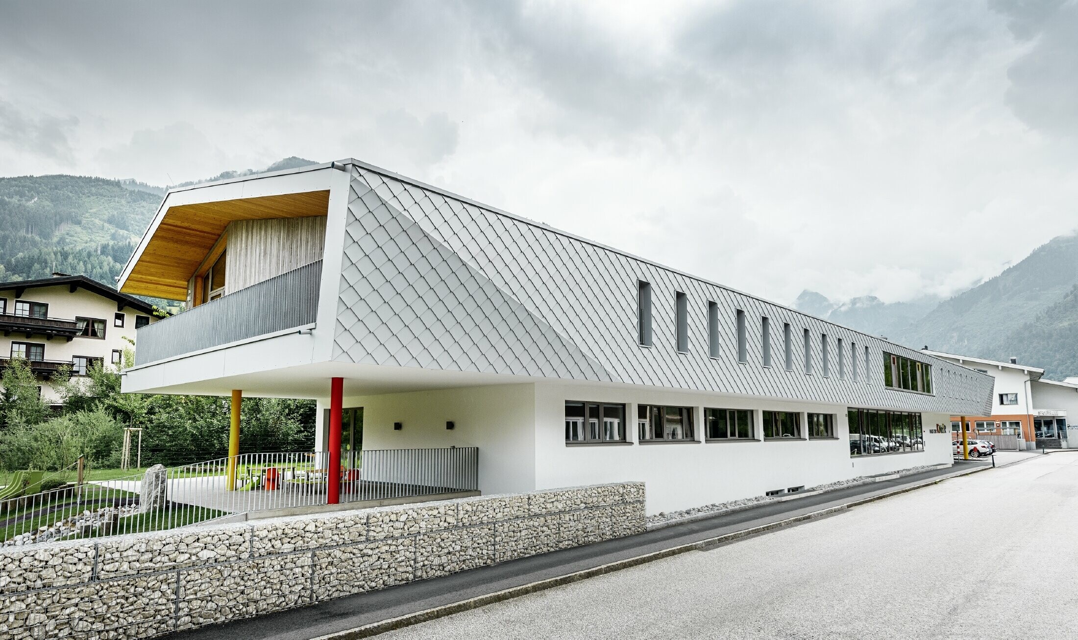 Newly constructed nursery school in Kaprun (Austria) with a modern aluminium façade with PREFA rhomboid façade tiles in prefa white