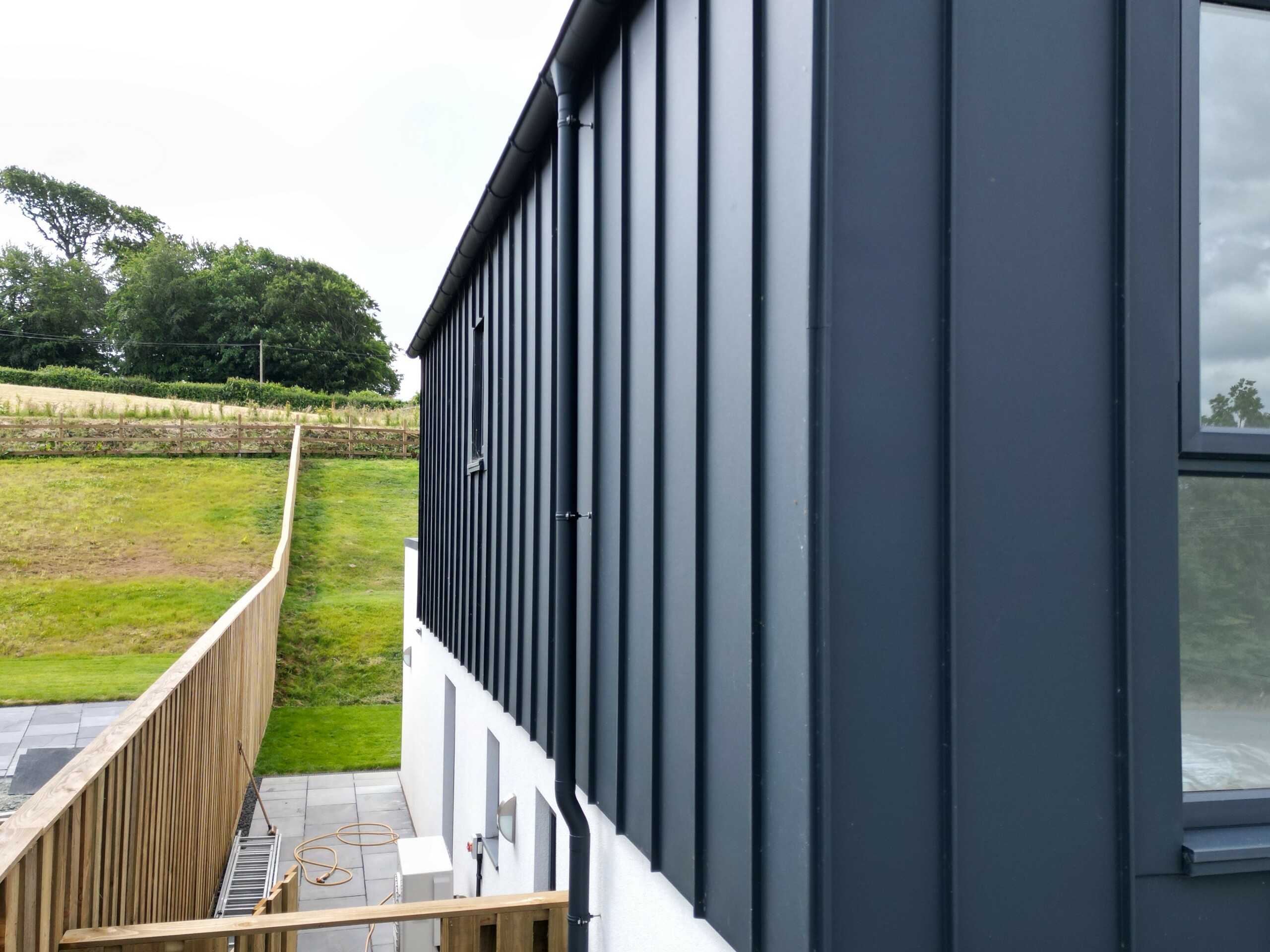 Close-up of the PREFALZ façade in P.10 anthracite, which highlights the high-quality aluminium and the precise workmanship of the standing seam covering. The clear lines and the UV-resistant surface make this façade a modern eye-catcher.