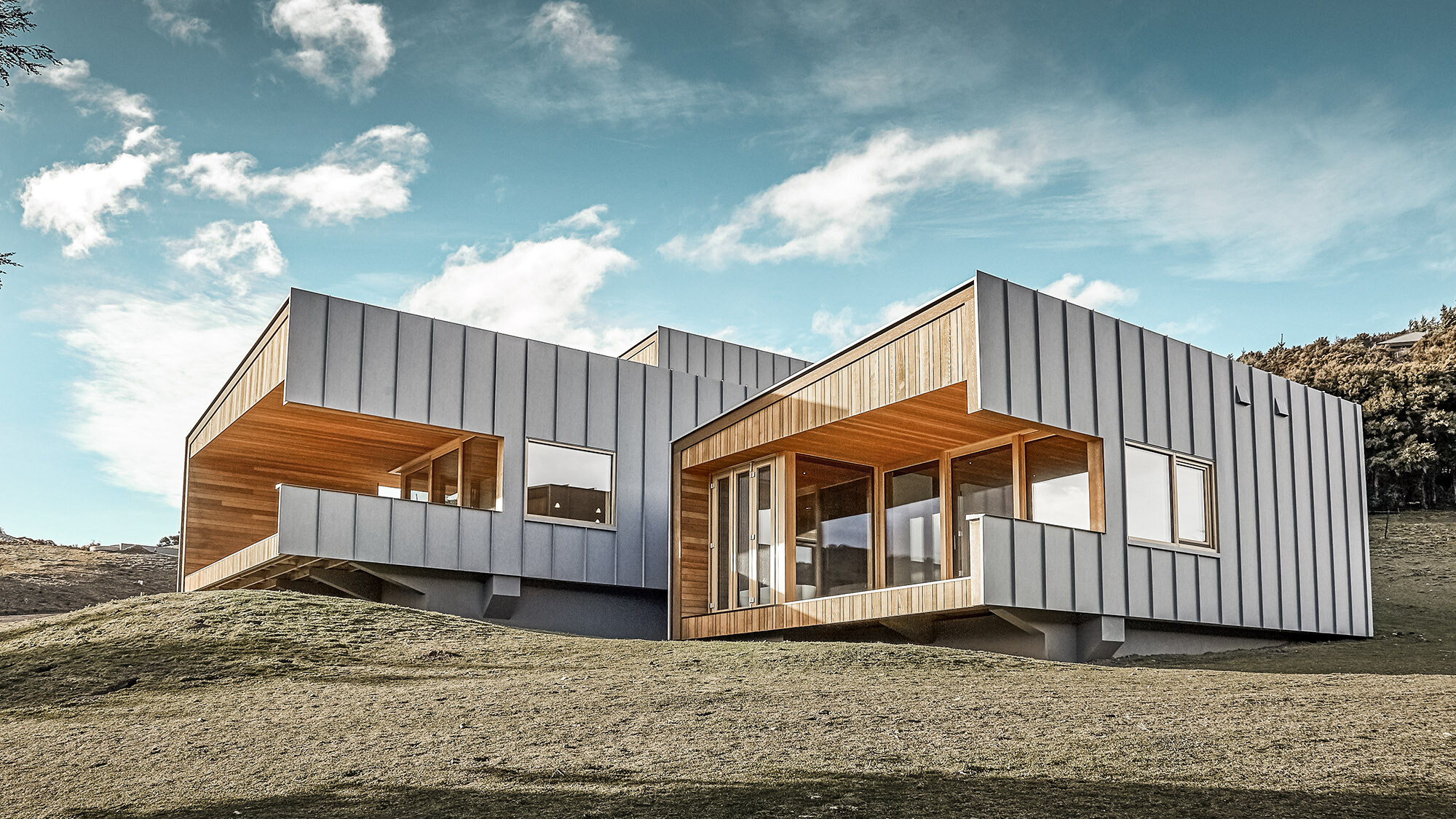 The building with its wooden core, enveloped by an aluminium façade, from a worm's eye view from the side.