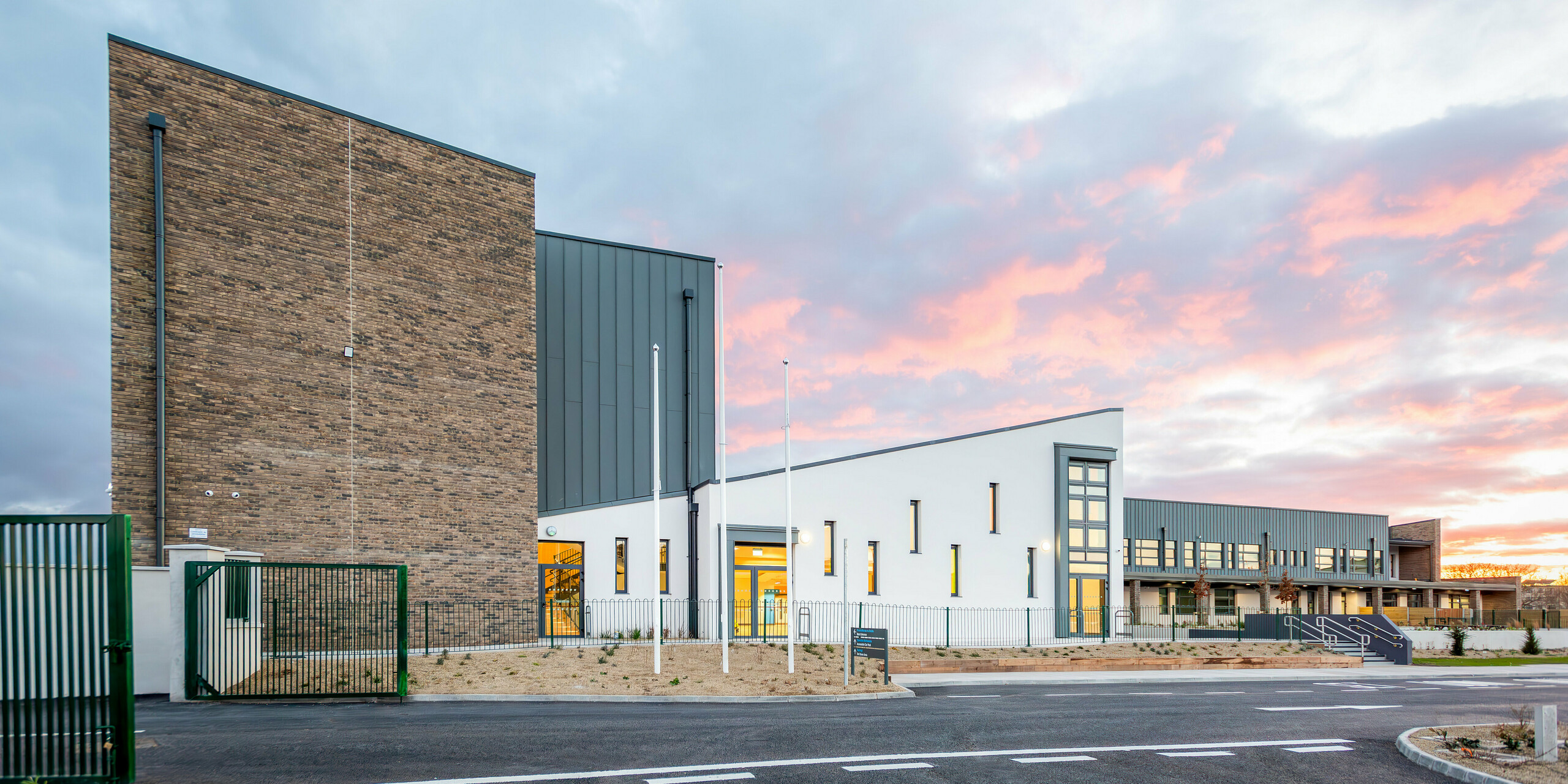 The modern school building of Scoil Mhuire Naofa in Carrigtwohill, Republic of Ireland, features a striking aluminium façade made of PREFALZ in P.10 light grey. The durable and weather-resistant standing seam roof covers around 800 m² and combines functionality with timeless aesthetics. The high-quality architecture is particularly effective against the backdrop of a picturesque sunset.