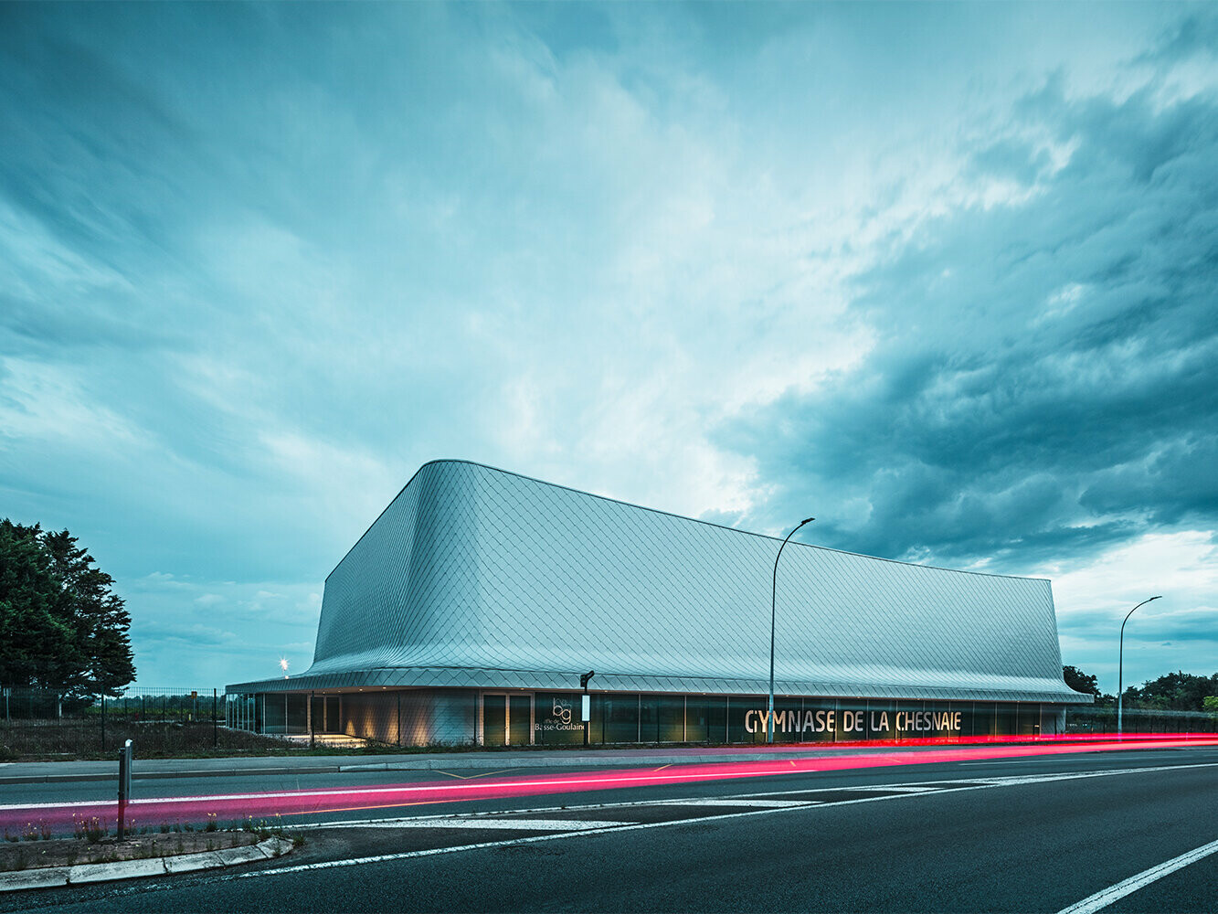 View of the sports hall from the street with a cloudy sky.