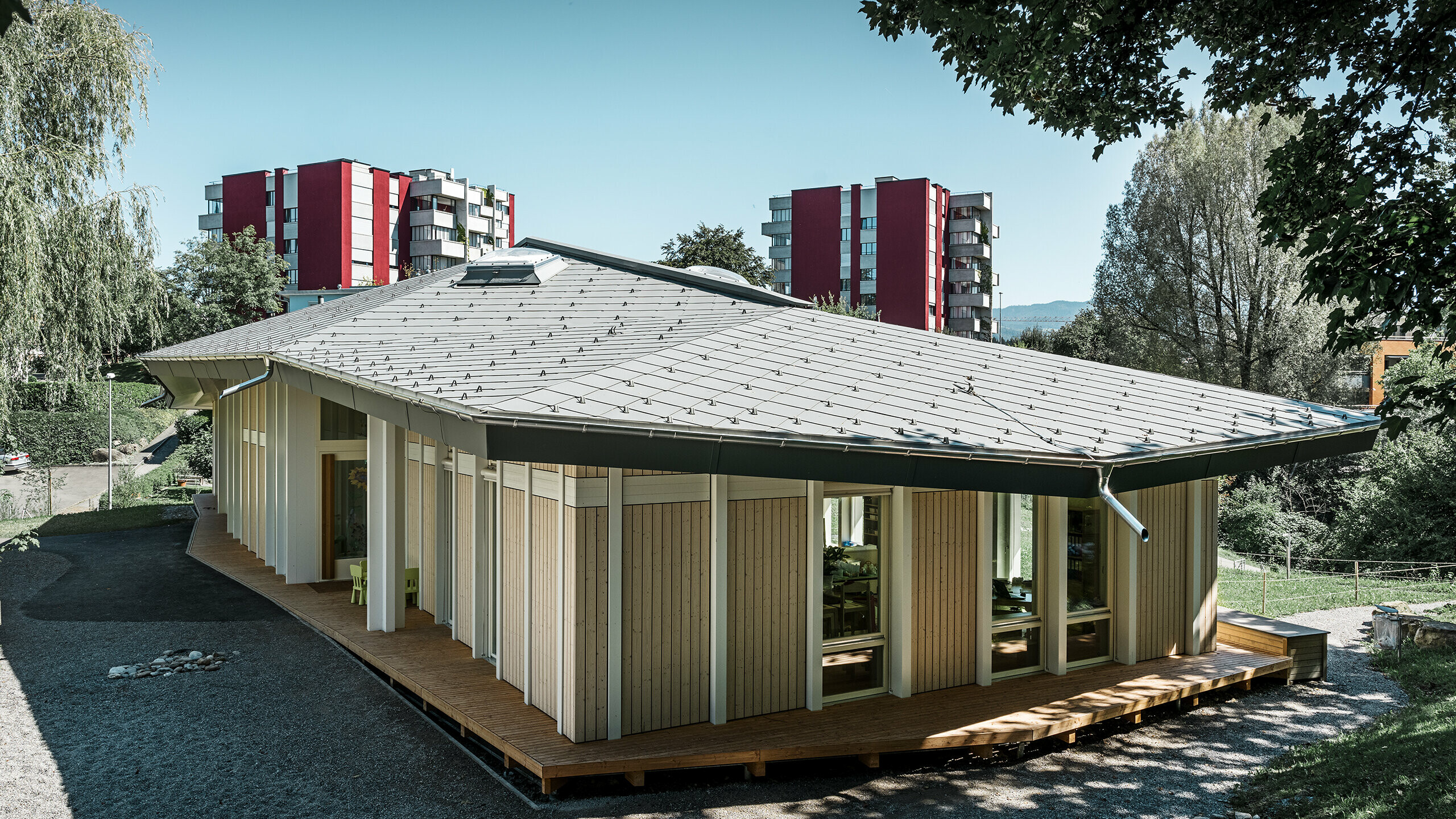 Single-storey kindergarten with vertical façade panels and aluminium roof from PREFA (rhomboid roof tile) in light grey