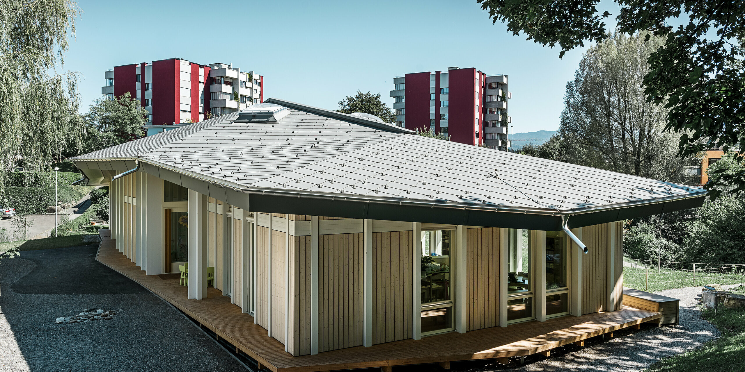 Single-storey kindergarten with vertical façade panels and aluminium roof from PREFA (rhomboid roof tile) in light grey