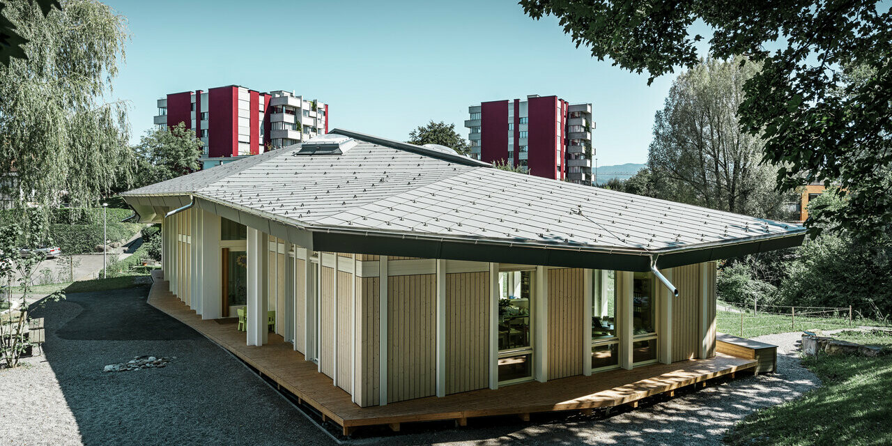 Single-storey kindergarten with vertical façade panels and aluminium roof from PREFA (rhomboid roof tile) in light grey