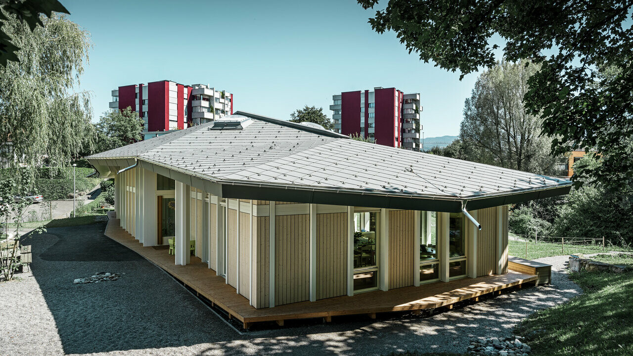 Single-storey kindergarten with vertical façade panels and aluminium roof from PREFA (rhomboid roof tile) in light grey