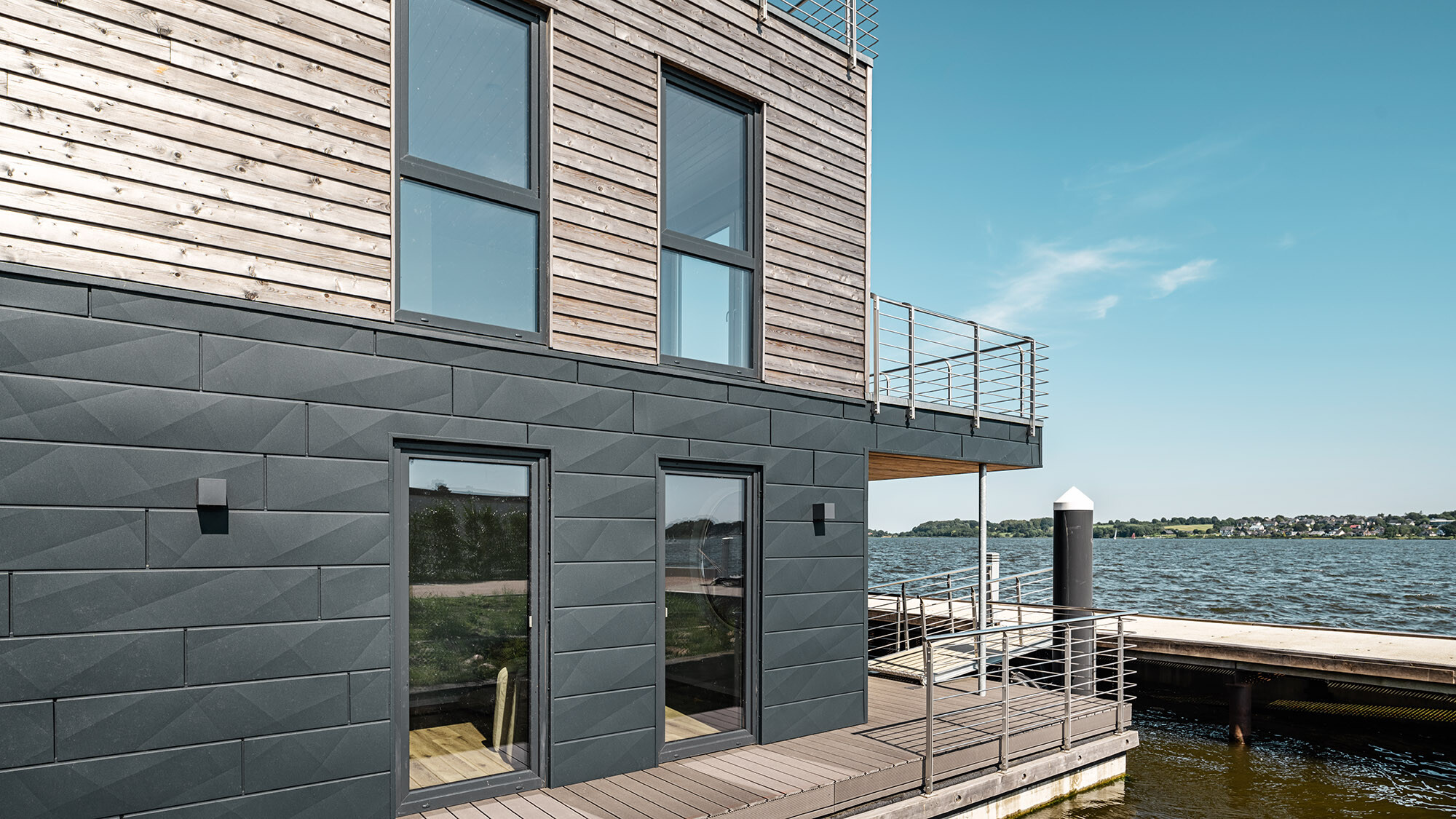 One of the water houses from the side, the jetty and the Schlei extending before it.