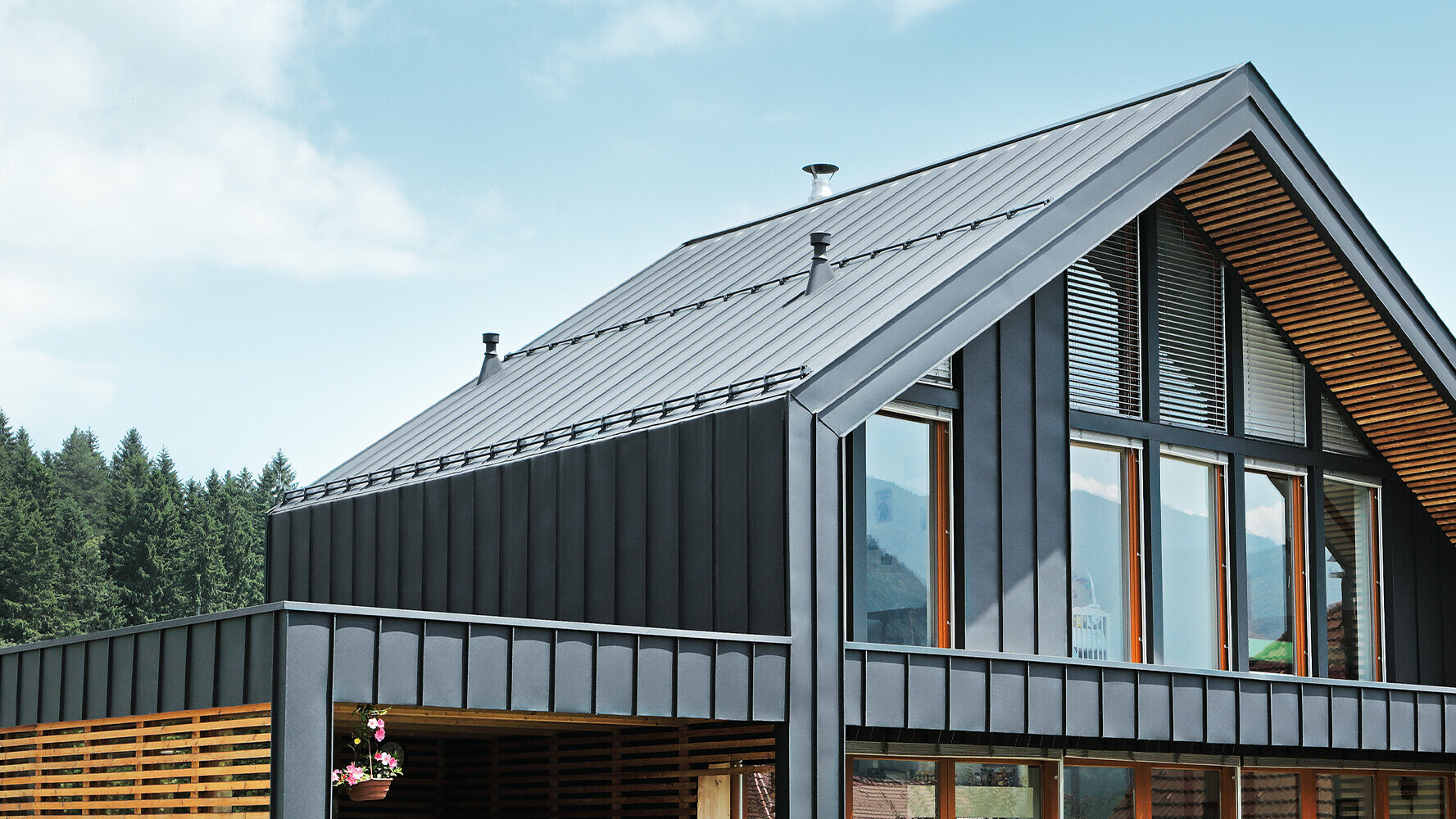 The modern detached house with large window areas was covered with  PREFA’s Prefalz material. The standing seam roof and the angled standing seam façade form a beautiful building envelope in anthracite.