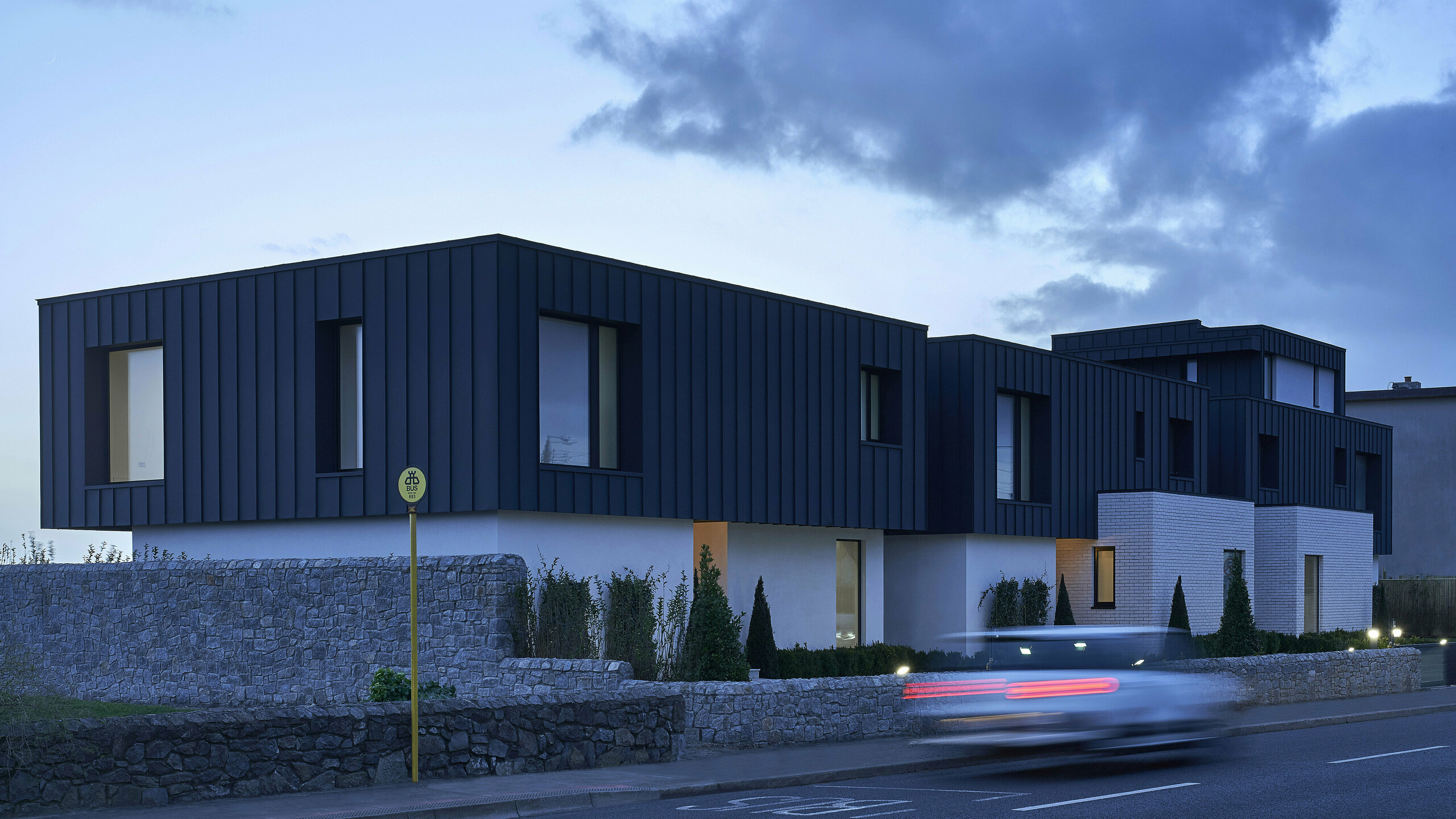 Picture of the residential houses with PREFALZ in the colour P.10 anthracite with cloudy weather.