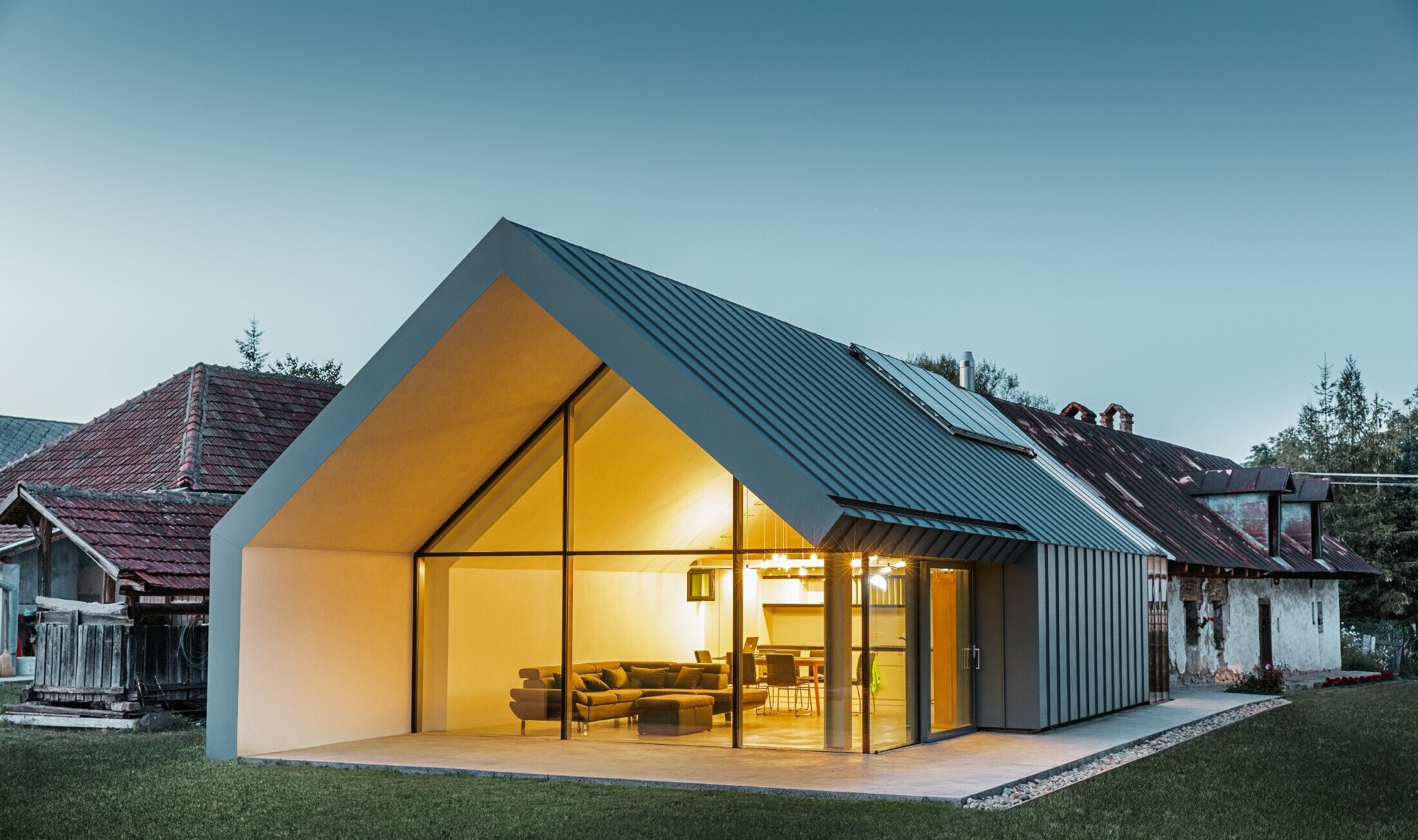Modern architect’s office and detached house adjoining an old farmhouse with a stone façade, clad in PREFA standing seam and single lock standing seam in light grey