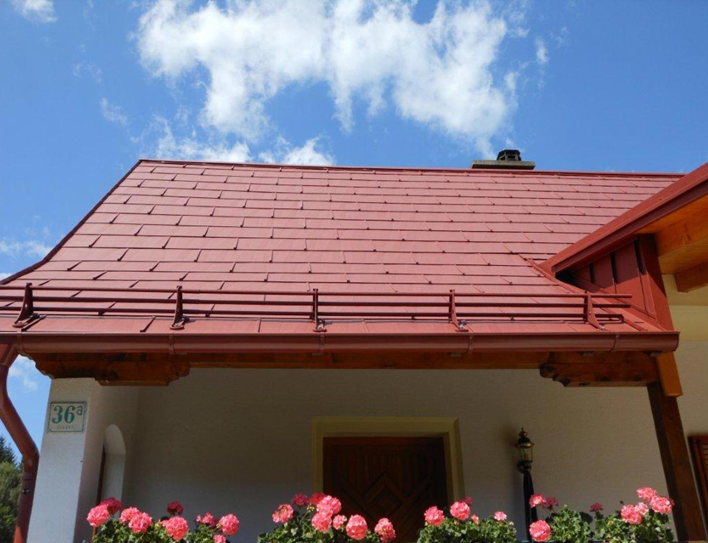 Detail of a roof surface with the PREFA FX.12 roof panel in oxide red with a snow load calculating system.